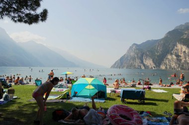 Karaya vurmuş turistlerle Garda Gölü manzarası. 15 Ağustos 2023 Riva del Garda, İtalya