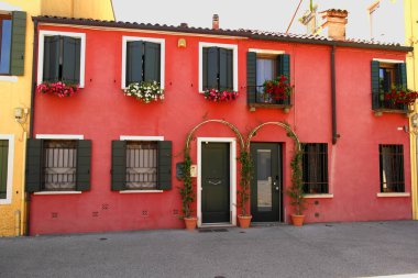 Piazza Portello 'daki balkonlarda çiçekli kırmızı bir ev. 27 Mayıs 2024 Padua, Veneto, İtalya