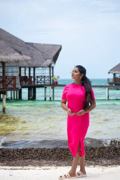 Picture of an Indian model in pink dress standing in the beaches in Maldives