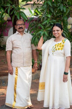 A Picture of middle aged malayali man and woman wearing a traditional kerala clothing clipart