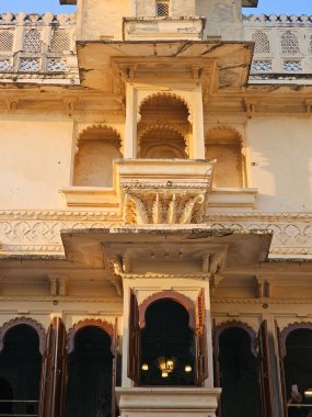 Udaipur Sarayı 'ndaki güzel mimarinin Rajasthan' a özgü olduğunu gösteren bir binanın resmi.