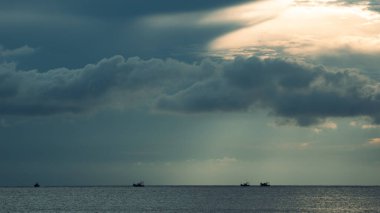 Fırtına öncesi sakin balıkçı tekneleri kara kara kara düşünen gökyüzünün altında sürüklenirken güneş Arap Denizi üzerindeki bulutları kesiyor. Goa 'da, okyanusun şiirle buluştuğu yerde..