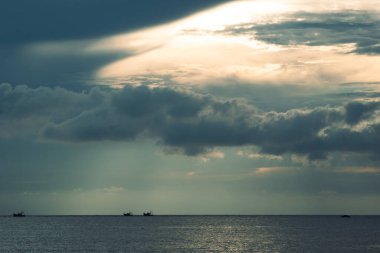 Fırtına öncesi sakin balıkçı tekneleri kara kara kara düşünen gökyüzünün altında sürüklenirken güneş Arap Denizi üzerindeki bulutları kesiyor. Goa 'da, okyanusun şiirle buluştuğu yerde..