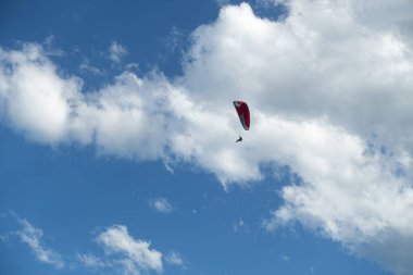 Mavi gökyüzünde süzülen paraglider          