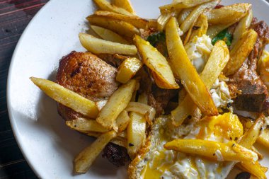 Kızarmış domuz pirzolası ve kızarmış patates.