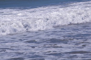 Deniz kıyısında el salla Mavi su