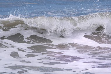 Deniz kenarında köpük ve dalgalar.