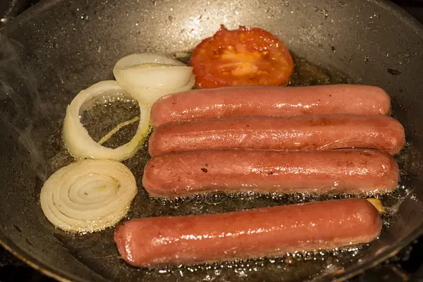 Domates ve soğanlı pişmiş sosis.