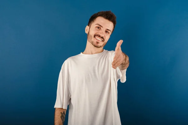 Młody Mężczyzna Uśmiecha Się Pewnie Nosząc Białą Koszulkę Pozując Niebieskim — Zdjęcie stockowe