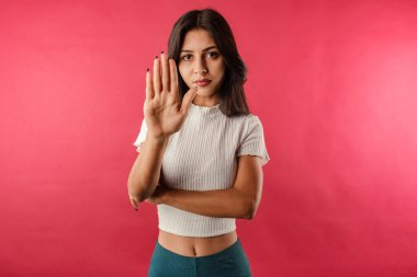 Kırmızı zemin üzerinde beyaz kurdeleli kırbaç izi var. Bu da avuç içi dur işaretini gösteriyor. Geçiş yok. Şimdi buna bir son ver! Yüzünde olumsuz ve ciddi bir jest olan uyarı ifadesi.