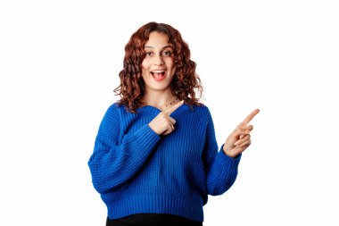 Cute millennial woman wearing pullover sweater standing isolated over white background smiling and looking at the camera pointing with two hands and fingers to the side.