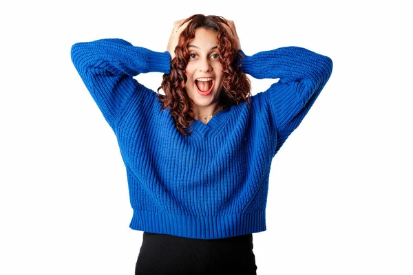 Portrait of woman wearing knitted sweater standing isolated over white background emotional surprised woman holding hands by the head and looking at camera. Very happy and cannot believe it.