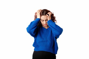 Portrait of cute woman standing isolated over white background holding head with hands suffers from a severe headache. Looks very angry and sick. A stressful life is taking its toll.