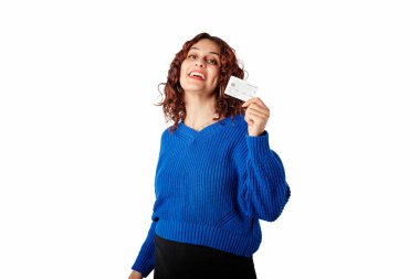 Young girl smiling happy wearing blue pullover sweater isolated over white background laughing and holding credit or bank card. Showing teeth.