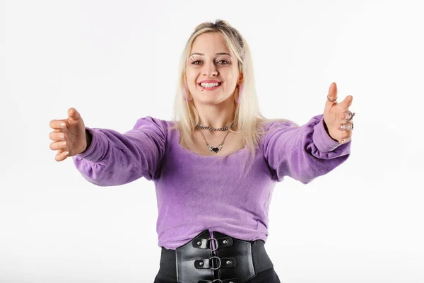 Young blonde girl smiling happy wearing ribbed blouse isolated over white background looking at the camera smiling with open arms for hug. Cheerful expression embracing happiness. Got some good news.