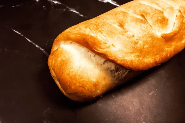 黒い大理石の背景に新鮮な自家製パン — ストック写真
