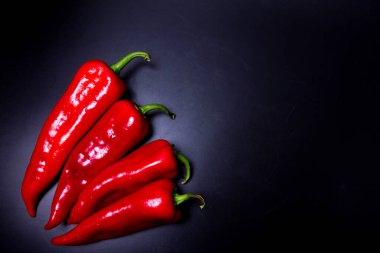 Siyah arka planda birkaç kırmızı biber.