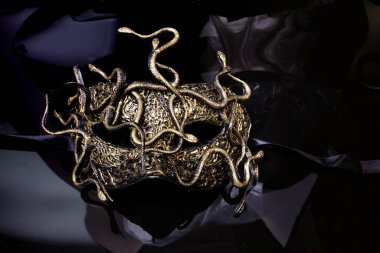 Siyah arka planda yılanlar olan karnaval maskesi.