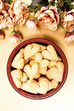 Çerezler kalpler ve çiçekler bej arka planda