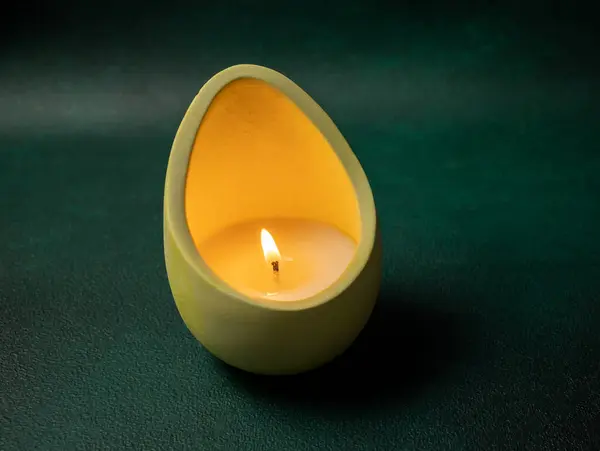 Burning massage candle on the green background