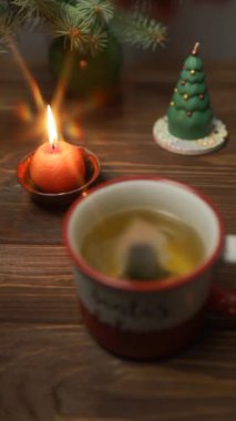 Noel şenlikli mumlar ve masada sıcak çay. 