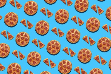 Bütünün sert ışık deseni ve pürüzsüz parlak mavi arka planda salam pizza parçaları, üst görünüm