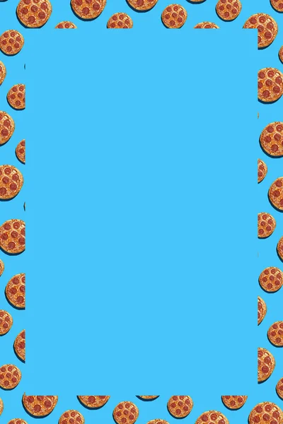一个由大的和小的腊肠比萨饼组成的硬而轻的图案 衬托着天衣无缝的明亮的蓝色背景 顶视图 矩形的文字空间 — 图库照片