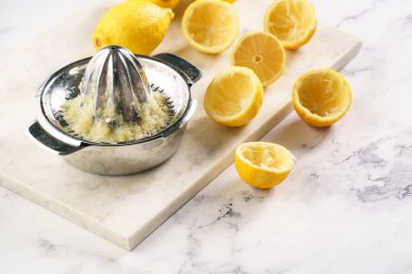 Birçok taze sarı limonun limon suyunu elle sıkmak, misket tahtasında sıkılmış limonlar.