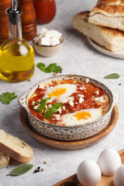 Geleneksel Kuzey Afrika yemekleri domates sosunda haşlanmış yumurta, zeytin yağı, dolma biber, soğan ve sarımsak, kimyon, kırmızı biber ve kırmızı biber ile baharatlı.