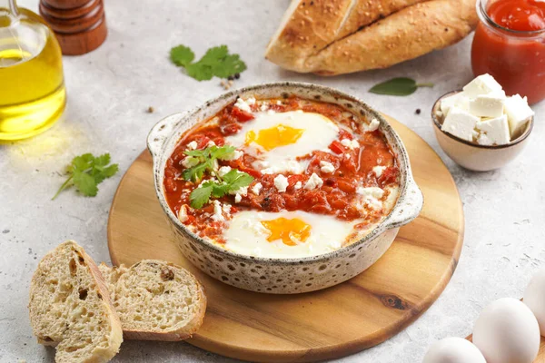 Traditional north african dish shakshouka made of eggs poached in a sauce of tomatoes, olive oil, bell peppers, onion and garlic, spiced with cumin, paprika and cayenne pepper