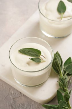 Kremalı süt yoğurdu tatlı kremalı krema, krem peynir, adaçayı ve limon suyu mermer tepside.