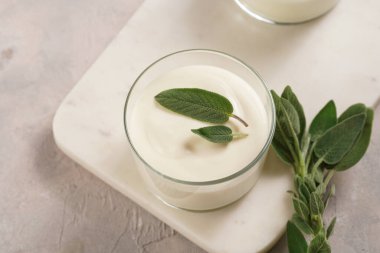 Kremalı süt yoğurdu tatlı kremalı krema, krem peynir, adaçayı ve limon suyu mermer tepside.