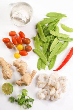 Baharatlı Tayland hindistan cevizi çorbası veya köri: kiraz domatesleri, bezelye, acı biber, limon, zencefil, karides ve taze kişniş.