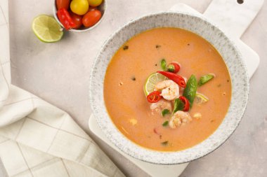 Hindistan cevizi çorbası ya da Hindistan cevizi sütü, kiraz domatesleri, bezelye, kırmızı biber, limon, zencefil, karides ve mermer kaplama üzerinde taze kişniş.