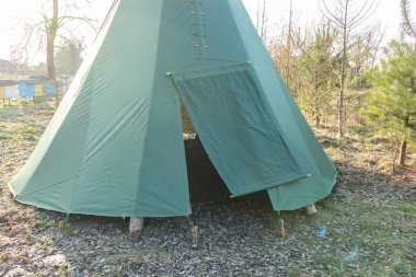 Baharın başında bahçeye kurulmuş yeşil çadır, geleneksel Hint konutu.