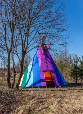 Bahçeye kurulmuş gökkuşağı renkli kızılderili çadırı, ilkbaharın başlarında, geleneksel Hint yerleşimi