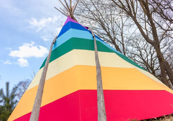 rainbow-coloured tepee set up in the garden, early spring, traditional Indian dwellin
