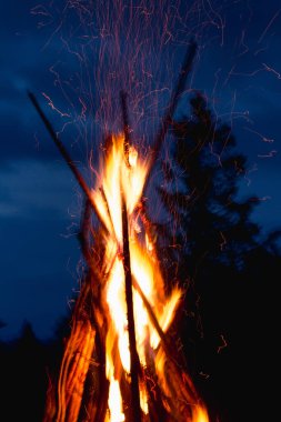 Captivating image of a massive conical bonfire during the Ivan Kupala celebration in the Carpathian mountains, illuminating the night sky clipart