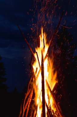 Captivating image of a massive conical bonfire during the Ivan Kupala celebration in the Carpathian mountains, illuminating the night sky clipart