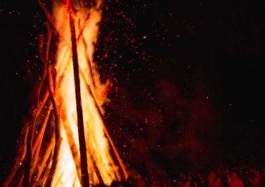 Karpatlar 'da büyük bir vatranın yanında Ivan Kupala' yı kutlayan insanların nefes kesici bir fotoğrafı, gece ışıkları ve gizemli bir atmosferle aydınlatılmış.