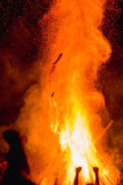 Karpatlar 'da büyük bir vatranın yanında Ivan Kupala' yı kutlayan insanların nefes kesici bir fotoğrafı, gece ışıkları ve gizemli bir atmosferle aydınlatılmış.