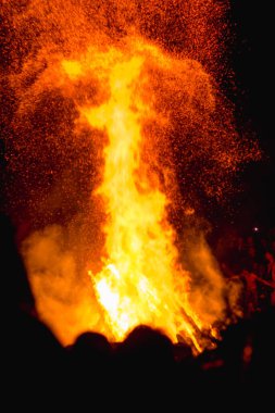 Karpatlar 'da büyük bir vatranın yanında Ivan Kupala' yı kutlayan insanların nefes kesici bir fotoğrafı, gece ışıkları ve gizemli bir atmosferle aydınlatılmış.