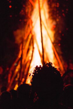 Karpatlar 'da büyük bir vatranın yanında Ivan Kupala' yı kutlayan insanların nefes kesici bir fotoğrafı, gece ışıkları ve gizemli bir atmosferle aydınlatılmış.