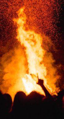 Karpatlar 'da büyük bir vatranın yanında Ivan Kupala' yı kutlayan insanların nefes kesici bir fotoğrafı, gece ışıkları ve gizemli bir atmosferle aydınlatılmış.