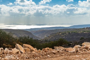 Kıbrıs Rum Kesimi 'nin berrak gökyüzü, az bulut ve sınırlı bitki örtüsü ile manzaralı sakin bir fotoğraf, adanın doğal güzelliğini gösteriyor