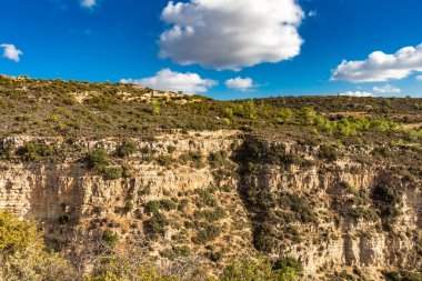 A secluded rock formation with sparse bushland in the mountains of Cyprus, reflecting the tranquility and natural beauty of the mountainous regio clipart