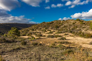 Kıbrıs Rum Kesimi 'nin berrak gökyüzü, az bulut ve sınırlı bitki örtüsü ile manzaralı sakin bir fotoğraf, adanın doğal güzelliğini gösteriyor