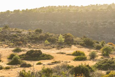 Kıbrıs Rum Kesimi 'nin berrak gökyüzü, az bulut ve sınırlı bitki örtüsü ile manzaralı sakin bir fotoğraf, adanın doğal güzelliğini gösteriyor