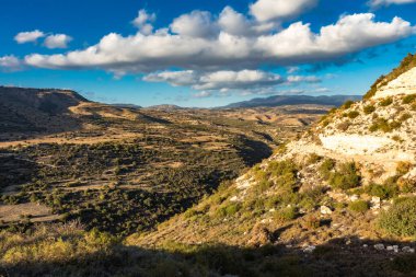 Kıbrıs Rum Kesimi 'nin berrak gökyüzü, az bulut ve sınırlı bitki örtüsü ile manzaralı sakin bir fotoğraf, adanın doğal güzelliğini gösteriyor