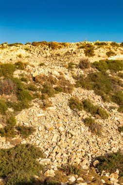 Kıbrıs Rum Kesimi 'nin berrak gökyüzü, az bulut ve sınırlı bitki örtüsü ile manzaralı sakin bir fotoğraf, adanın doğal güzelliğini gösteriyor